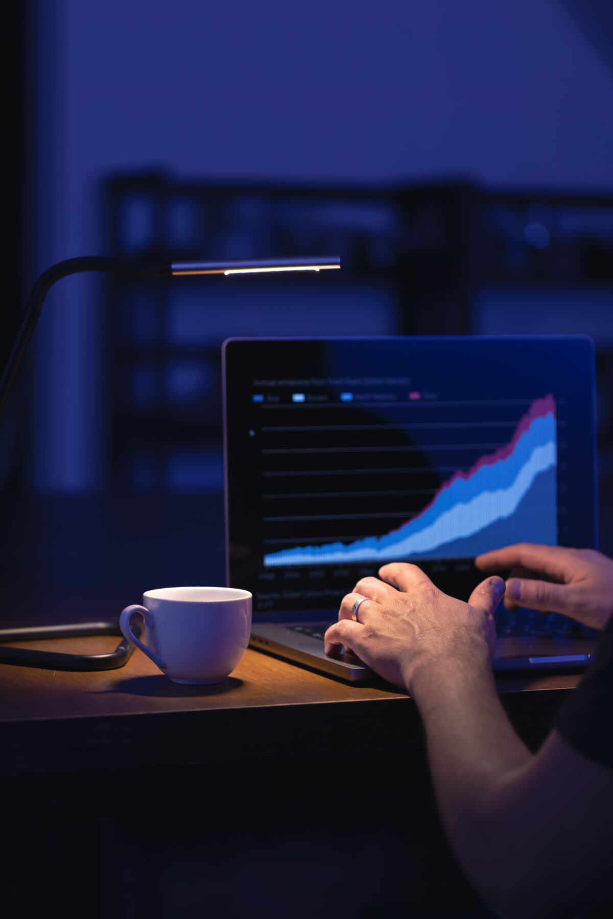 Broker looking at laptop analyzing stock market invest trading stocks graph.